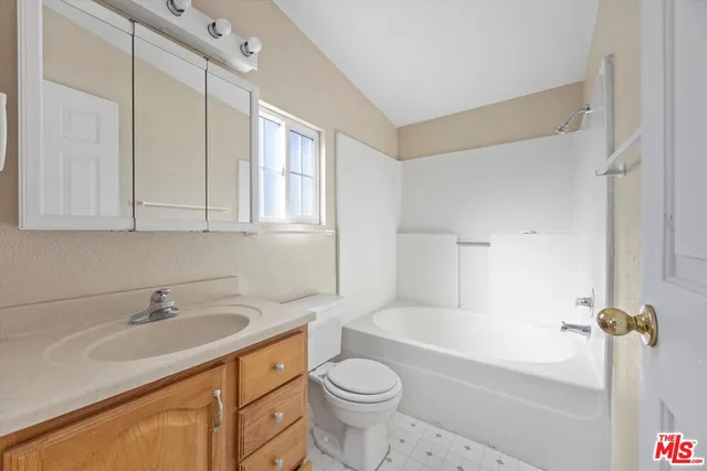 a bathroom with a sink toilet vanity and bathtub