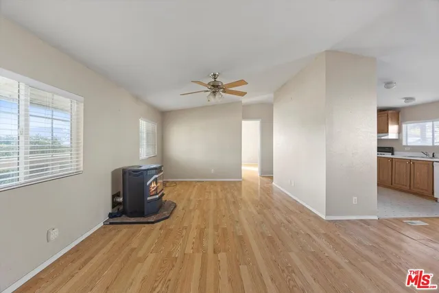 a view of a livingroom with wooden floor and a ceiling fan