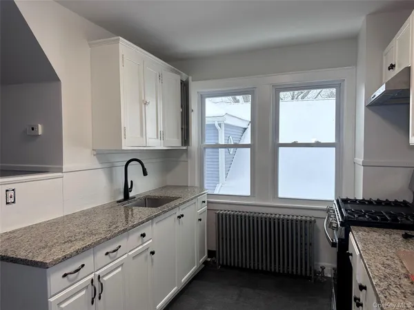 a kitchen with a sink stove and cabinets