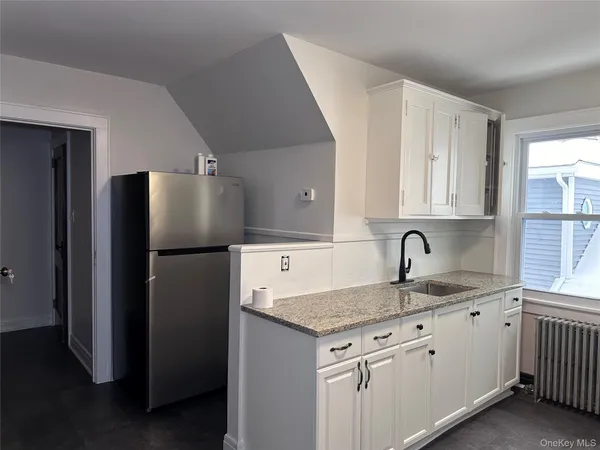a kitchen with stainless steel appliances granite countertop a sink and a refrigerator
