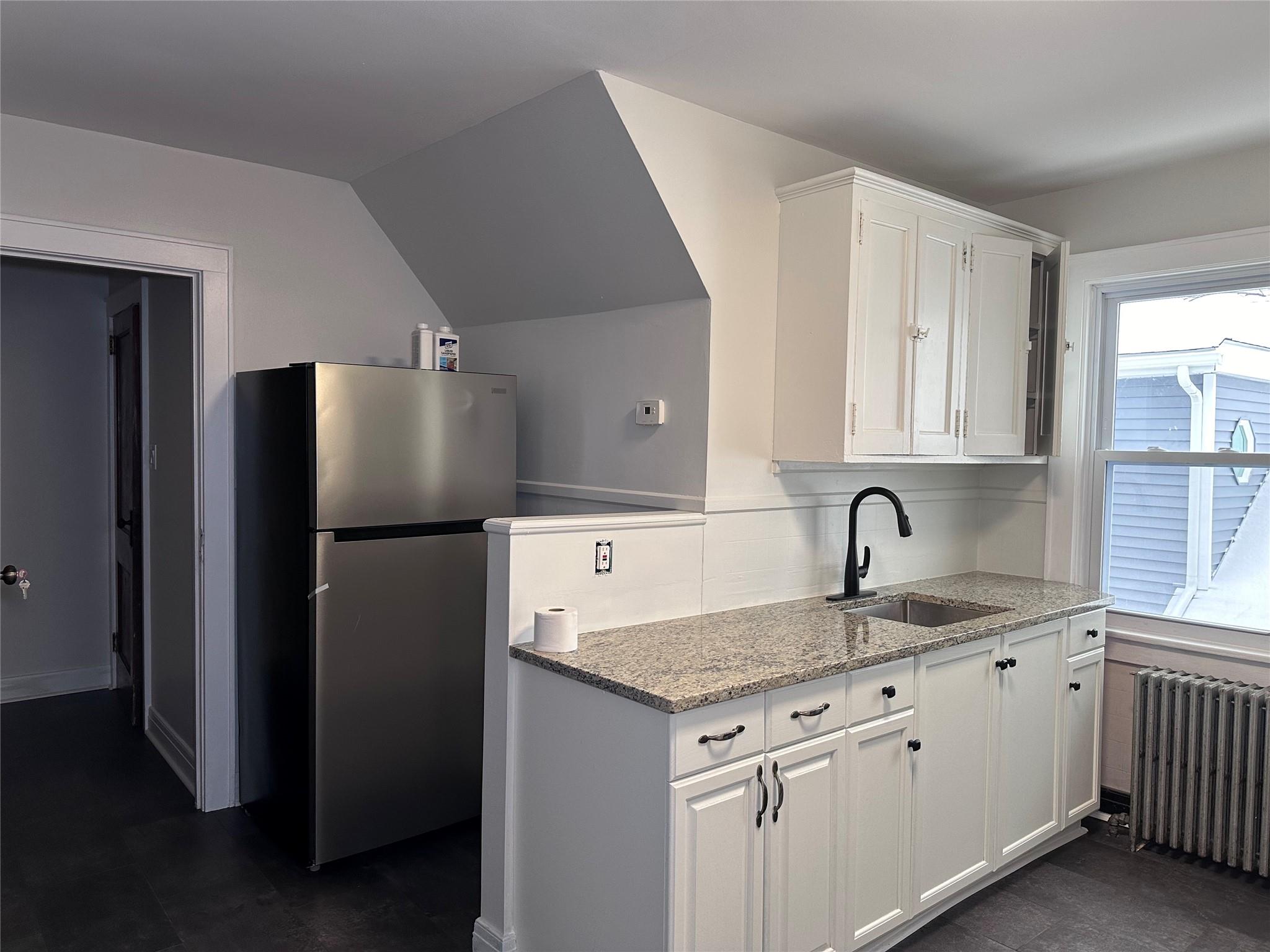 39 Adams Street, Unit 2 Poughkeepsie, NY 12601 - Photo 3 of 12 a kitchen with kitchen island granite countertop a sink stove and refrigerator