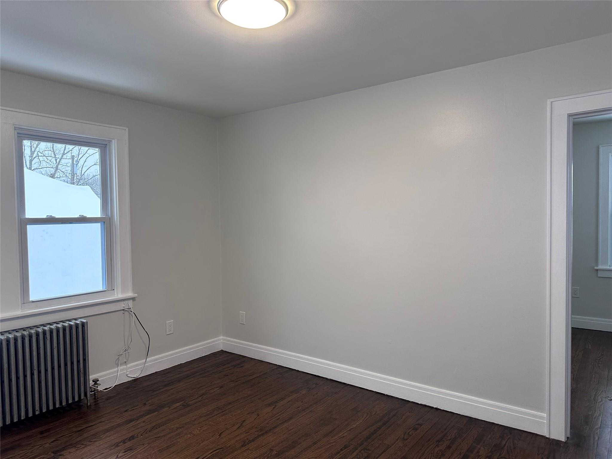 39 Adams Street, Unit 2 Poughkeepsie, NY 12601 - Photo 4 of 12 a view of an empty room with wooden floor and a window