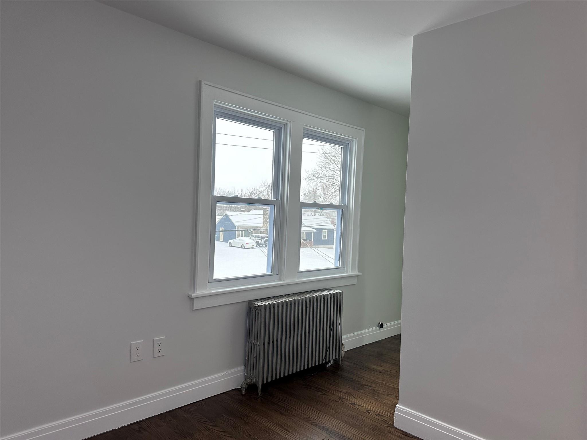39 Adams Street, Unit 2 Poughkeepsie, NY 12601 - Photo 8 of 12 an empty room with wooden floor and windows