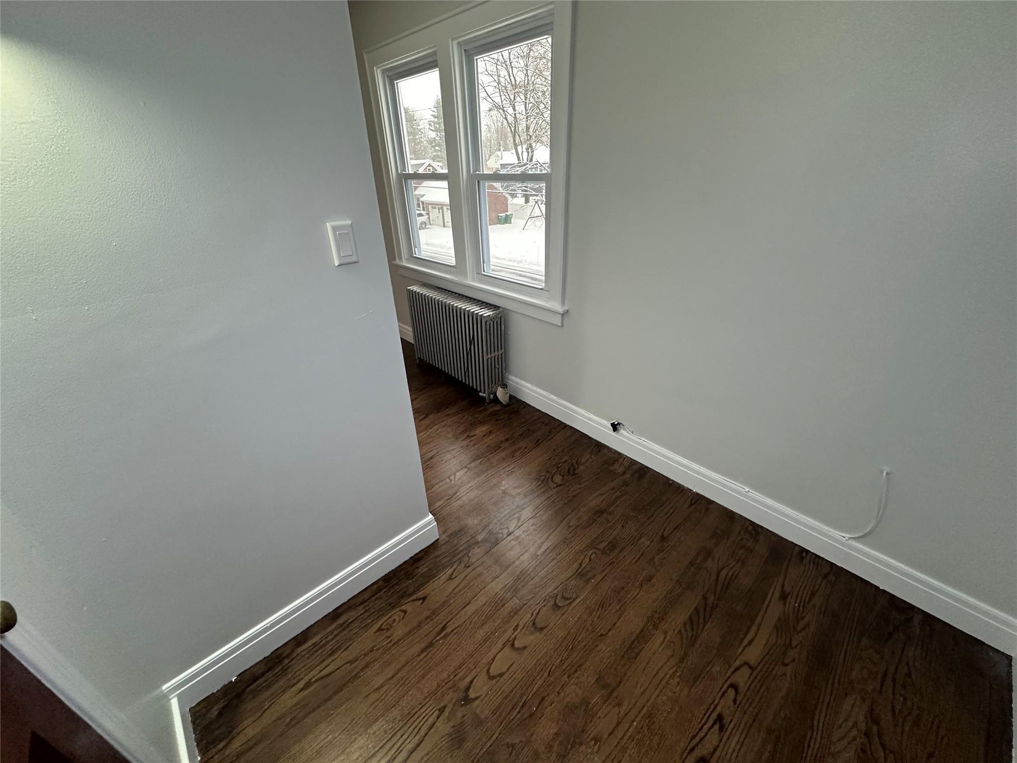 39 Adams Street, Unit 2 Poughkeepsie, NY 12601 - Photo 9 of 12 an empty room with wooden floor and windows