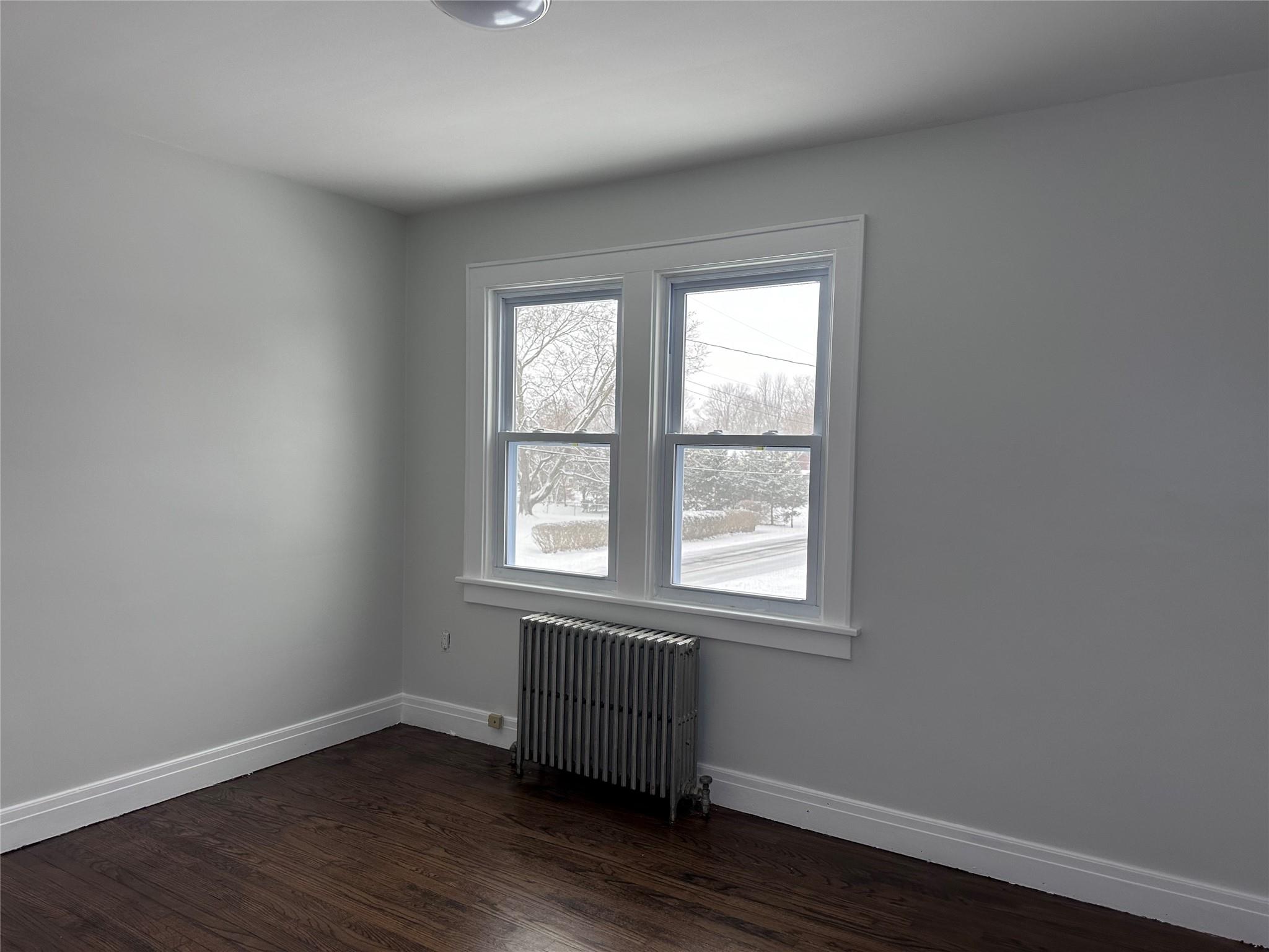 39 Adams Street, Unit 2 Poughkeepsie, NY 12601 - Photo 10 of 12 an empty room with wooden floor and windows