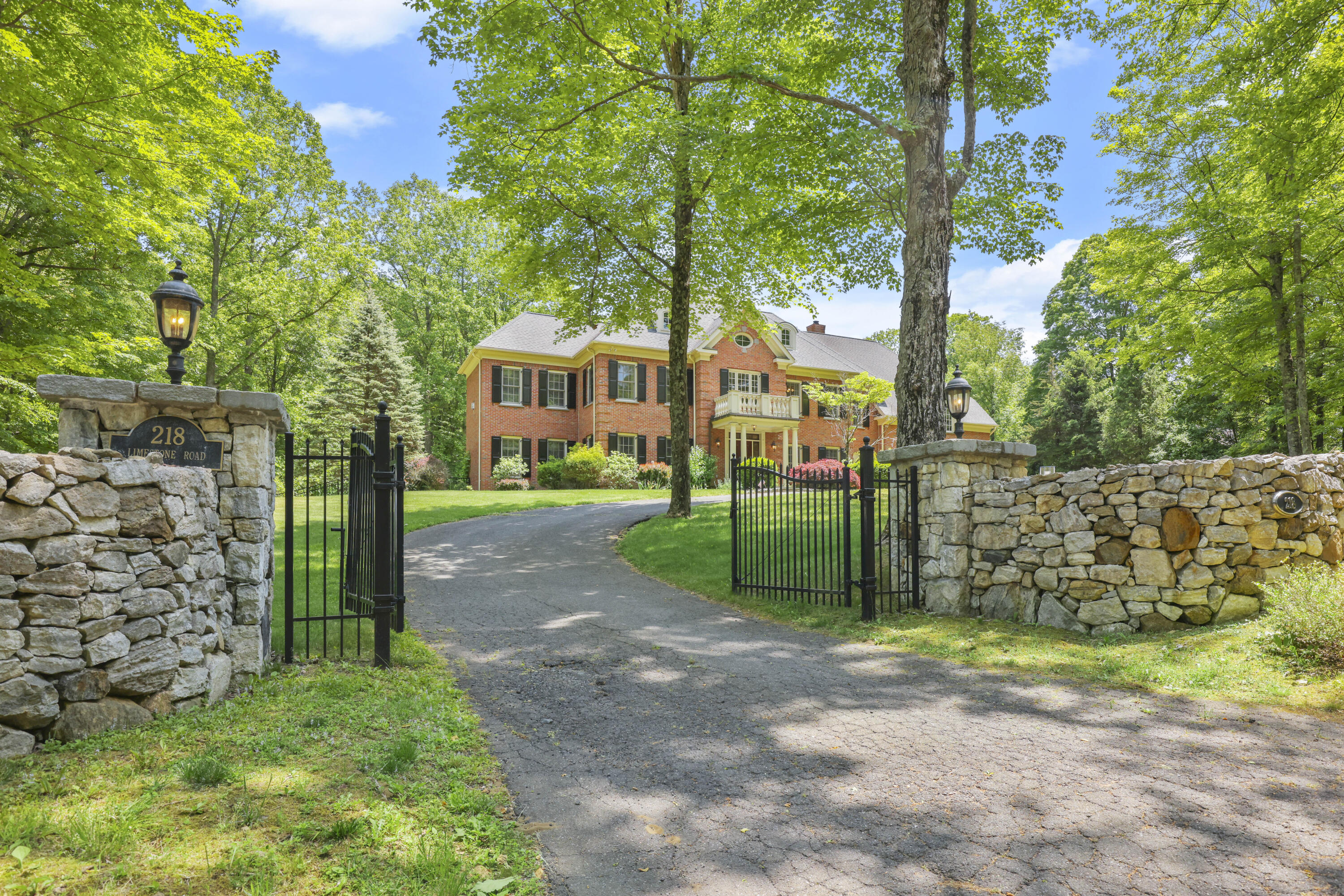 218 Limestone Road Ridgefield, CT 06877 - Photo 3 of 41 a view of a house with a small yard and large trees