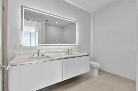 a bathroom with a toilet a sink and mirror