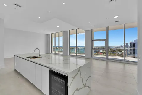 a open kitchen with kitchen island a sink and a view of living room