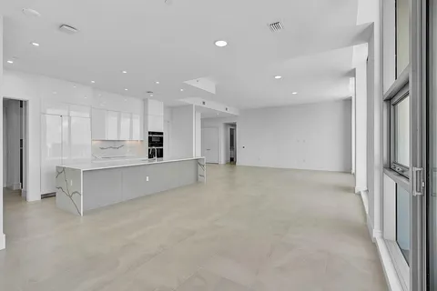 a view of a kitchen with refrigerator and white cabinets