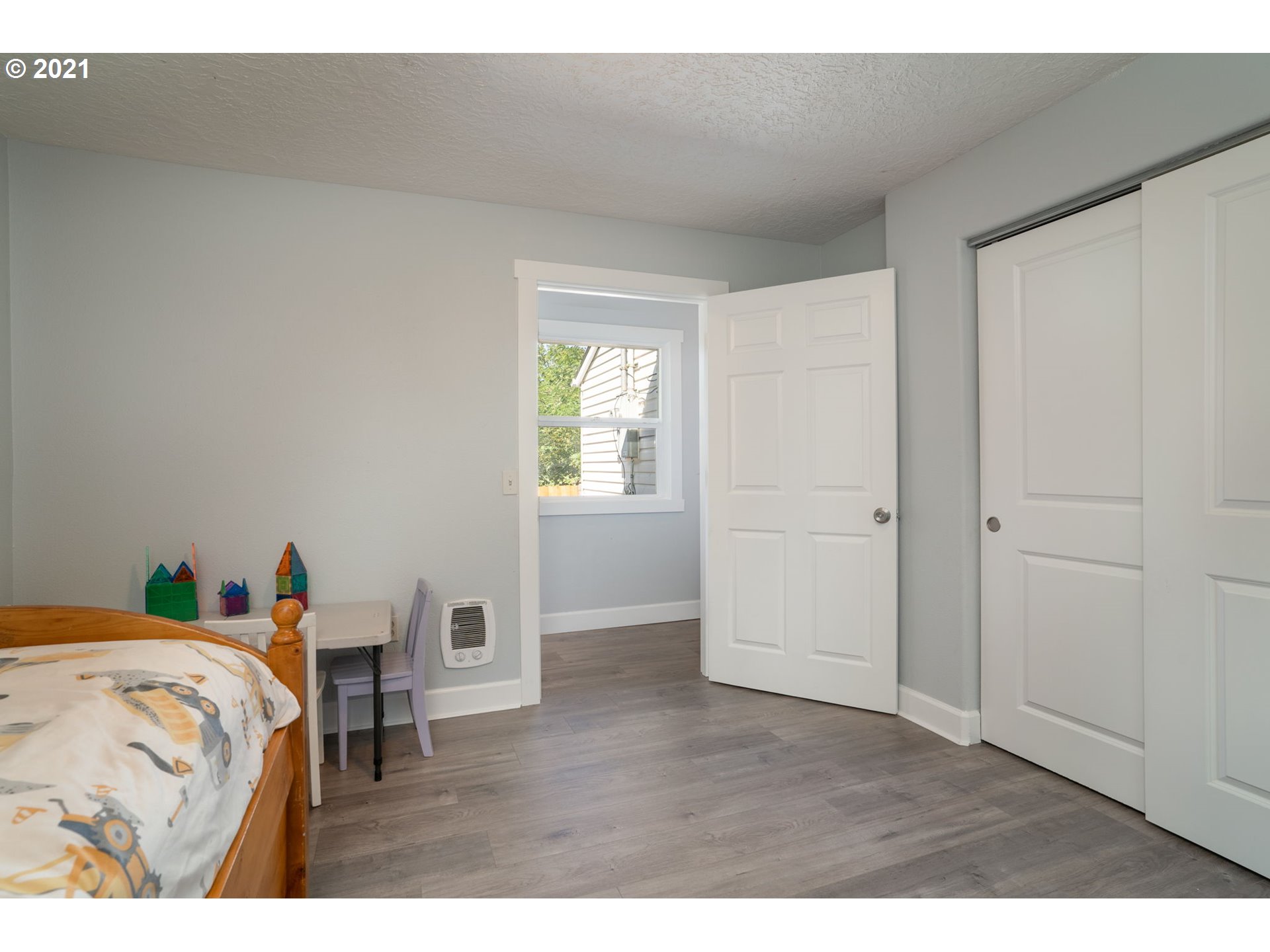 5720 Southeast Jenne Road Portland, OR 97236 - Photo 12 of 23 a bedroom with a bed and a chandelier
