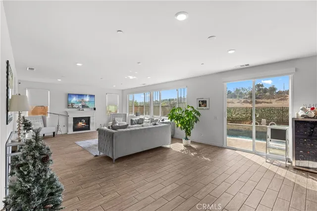a living room with furniture large window and wooden floor