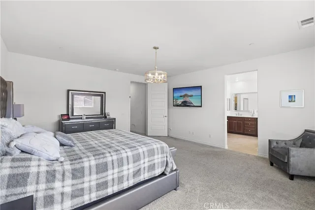 a bedroom with a large bed and a chandelier