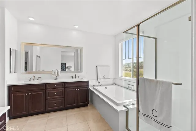 a spacious bathroom with a tub sink shower and mirror