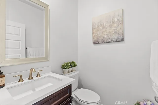a bathroom with a sink vanity mirror and toilet