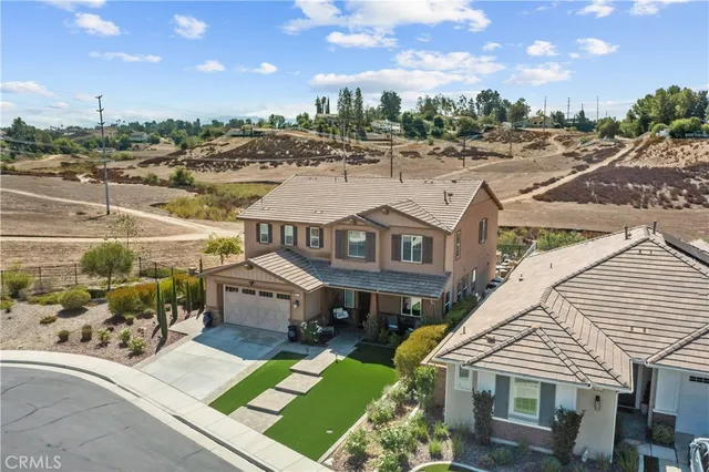 a aerial view of a house with a yard table and chairs