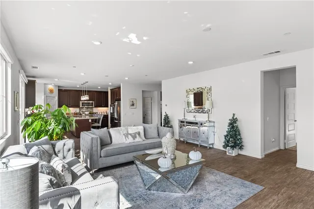 a living room with furniture kitchen view and a potted plant