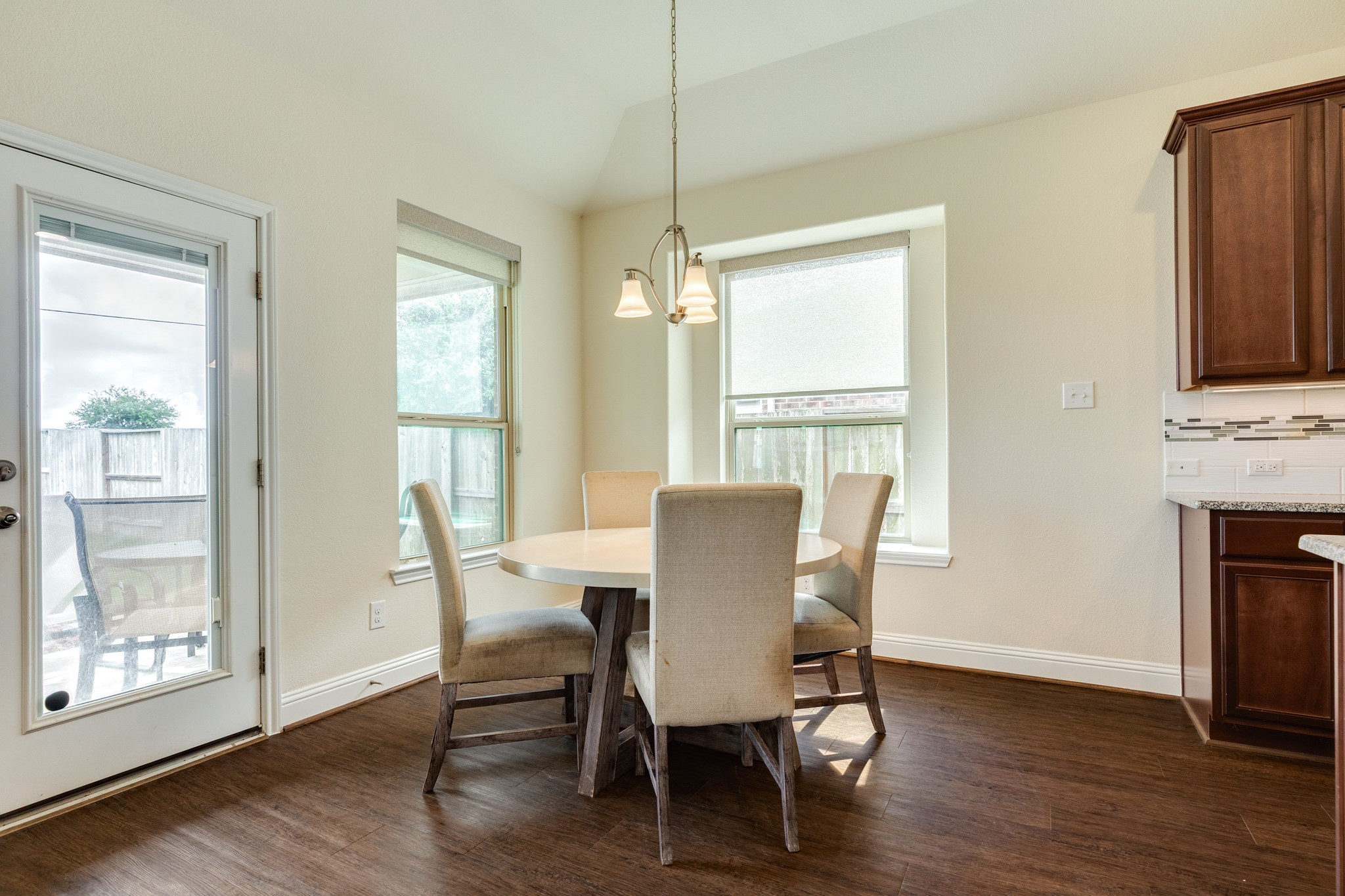 3519 Bay Drive Rosharon, TX 77583 - Photo 18 of 49 Bright and airy dining area surrounded by expansive windows, featuring a back door with an integrated hidden blind for adjustable privacy.
