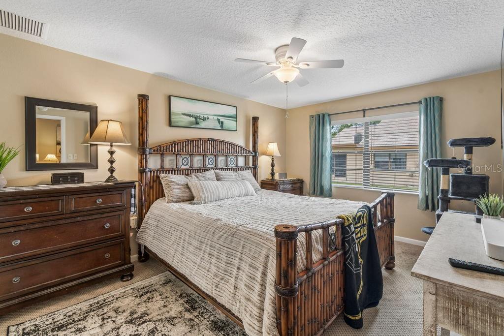 4753 Sunny Loop Holiday, FL 34690 - Photo 17 of 39 a bedroom with a large bed and a chandelier