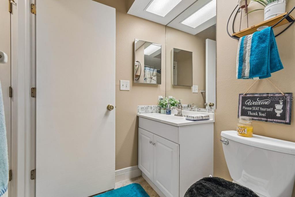 4753 Sunny Loop Holiday, FL 34690 - Photo 29 of 39 a bathroom with a sink a toilet and mirror