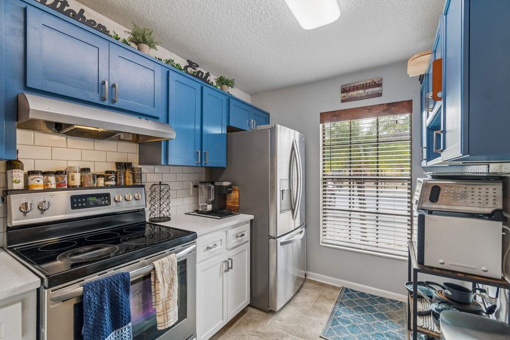 4753 Sunny Loop Holiday, FL 34690 - Photo 9 of 39 a kitchen with stainless steel appliances granite countertop a stove a sink and a refrigerator