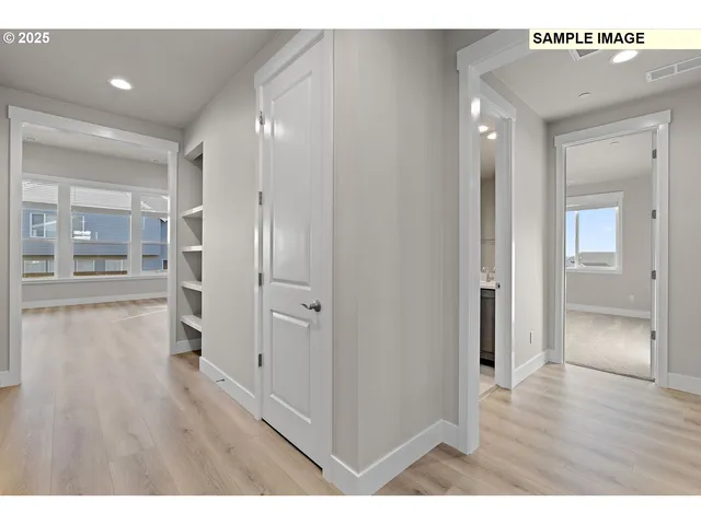 a view of an empty room with wooden floor and a fireplace
