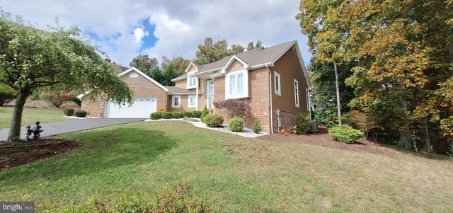 a view of a house with a yard and tree s