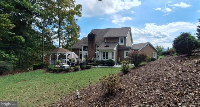 a front view of a house with a garden and trees