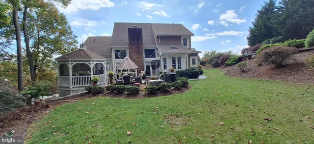 a front view of a house with garden and a tree