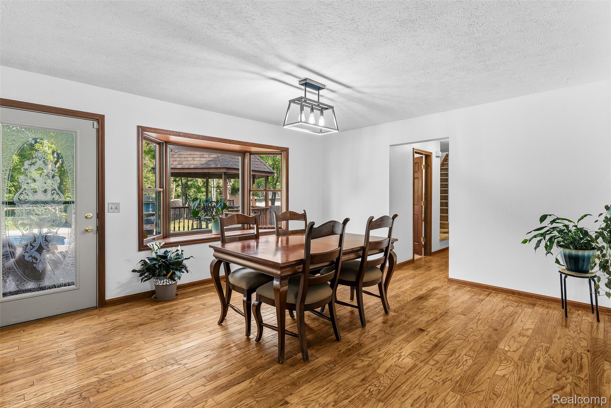 6699 Lansing Road Durand, MI 48429 - Photo 11 of 53 Hardwood flooring extends throughout this room, featuring a decorative glass entry door and a large bay window