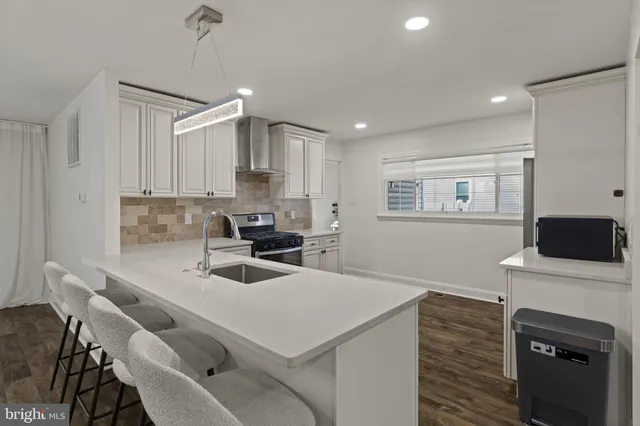 a kitchen with stainless steel appliances granite countertop a table chairs and a refrigerator