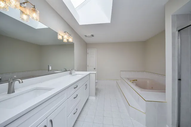 a bathroom with a tub sink and mirror