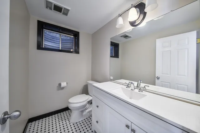 a bathroom with a sink a toilet and a mirror