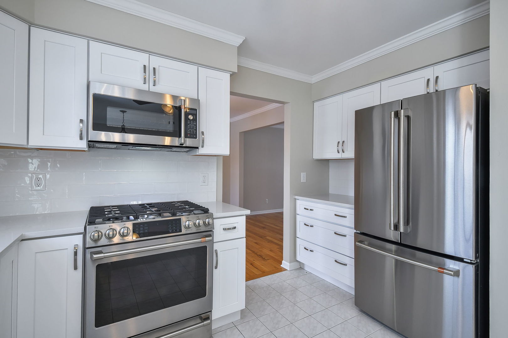 389 Colonial Circle Geneva, IL 60134 - Photo 5 of 25 a kitchen with stainless steel appliances white cabinets white stove a microwave and a refrigerator