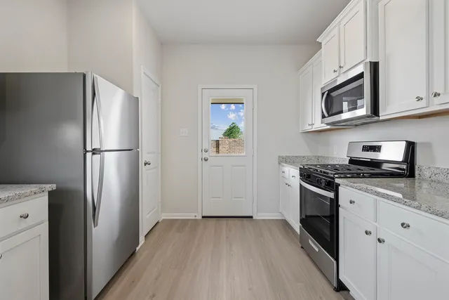 a kitchen with stainless steel appliances granite countertop a refrigerator stove and microwave