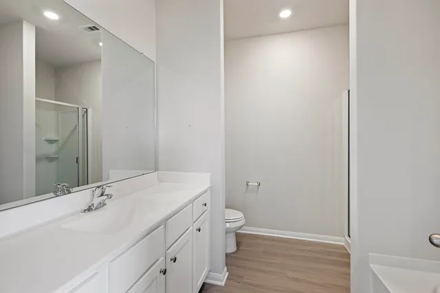 a bathroom with a sink a toilet and shower