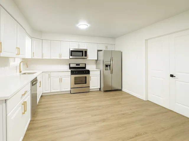 a kitchen with cabinets stainless steel appliances and sink