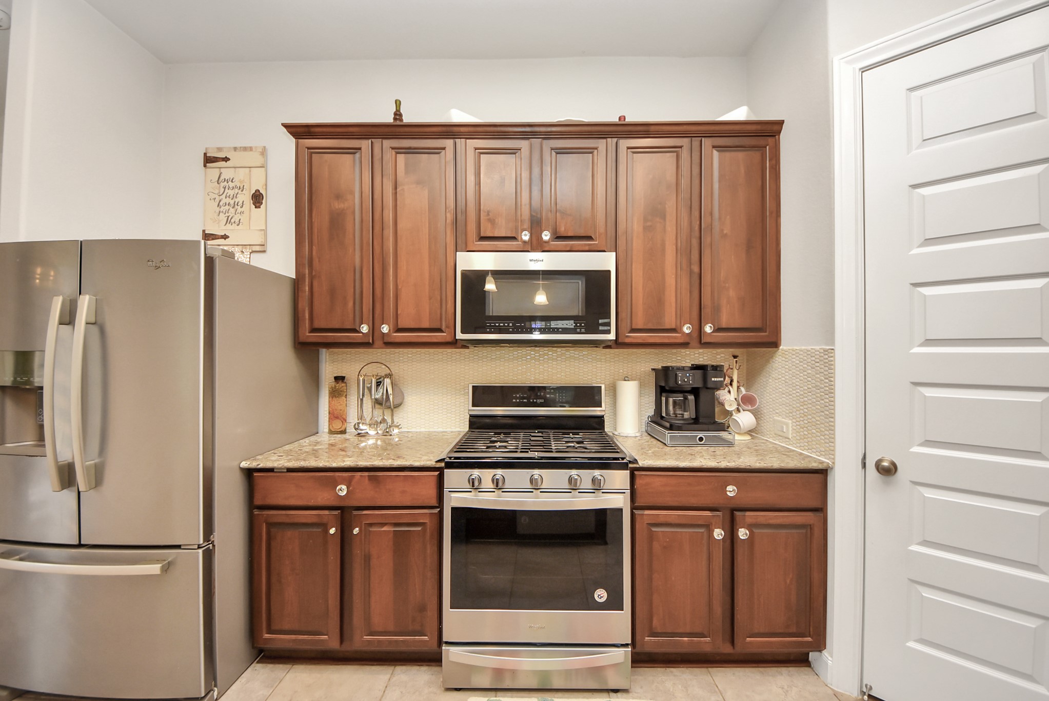 8806 Chapada Highlands Drive Cypress, TX 77433 - Photo 12 of 42 a kitchen with granite countertop a stove microwave and refrigerator