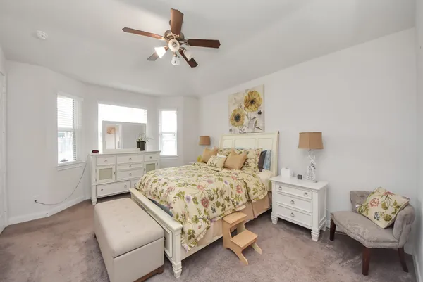 a bedroom with a bed a couch and a chandelier