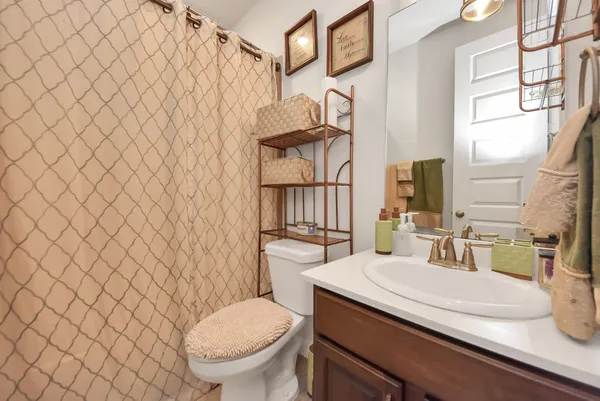 a bathroom with a granite countertop toilet sink and mirror