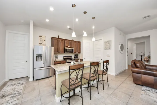 a kitchen with stainless steel appliances kitchen island granite countertop a refrigerator and microwave