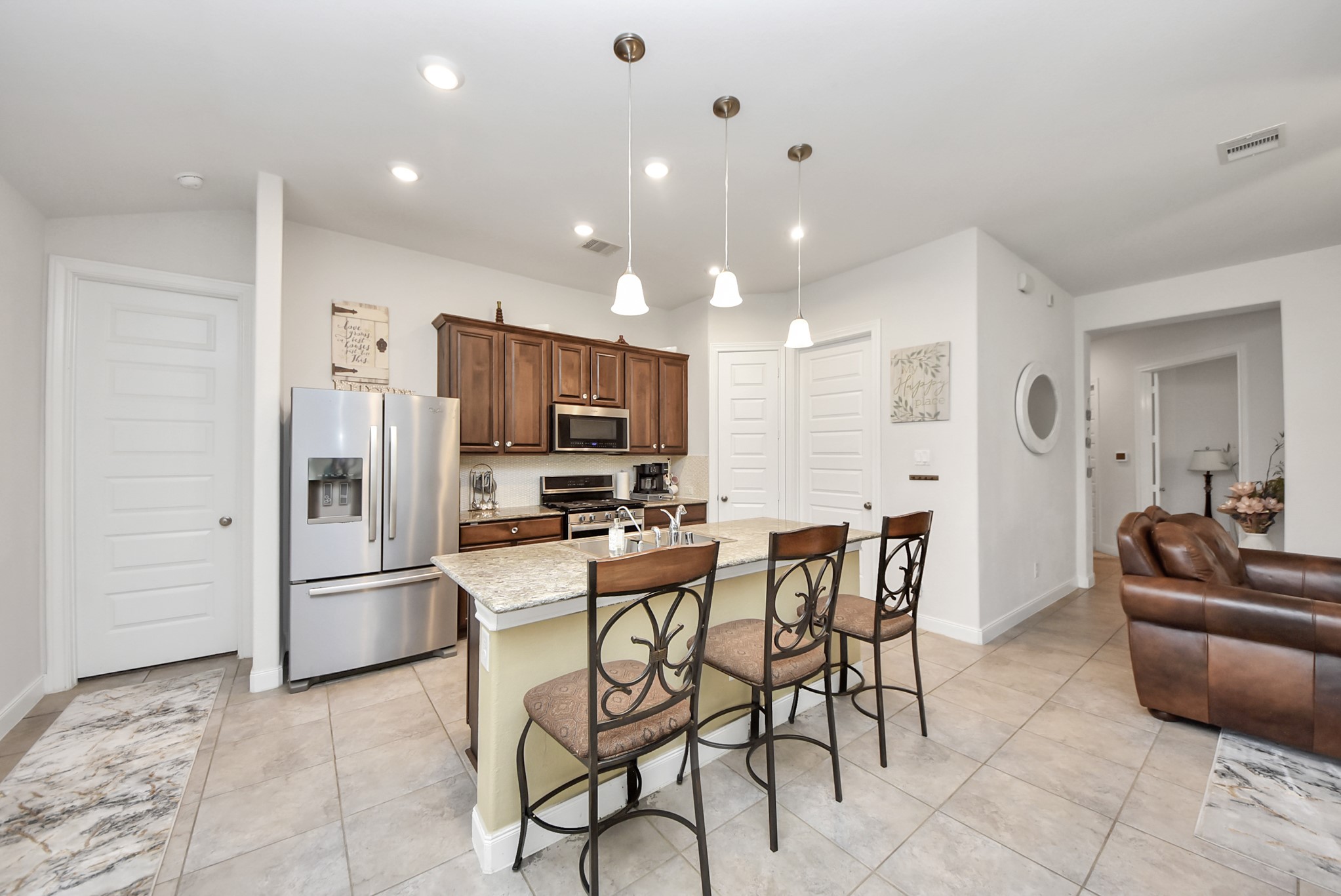 8806 Chapada Highlands Drive Cypress, TX 77433 - Photo 6 of 42 a kitchen with stainless steel appliances kitchen island granite countertop a refrigerator and microwave