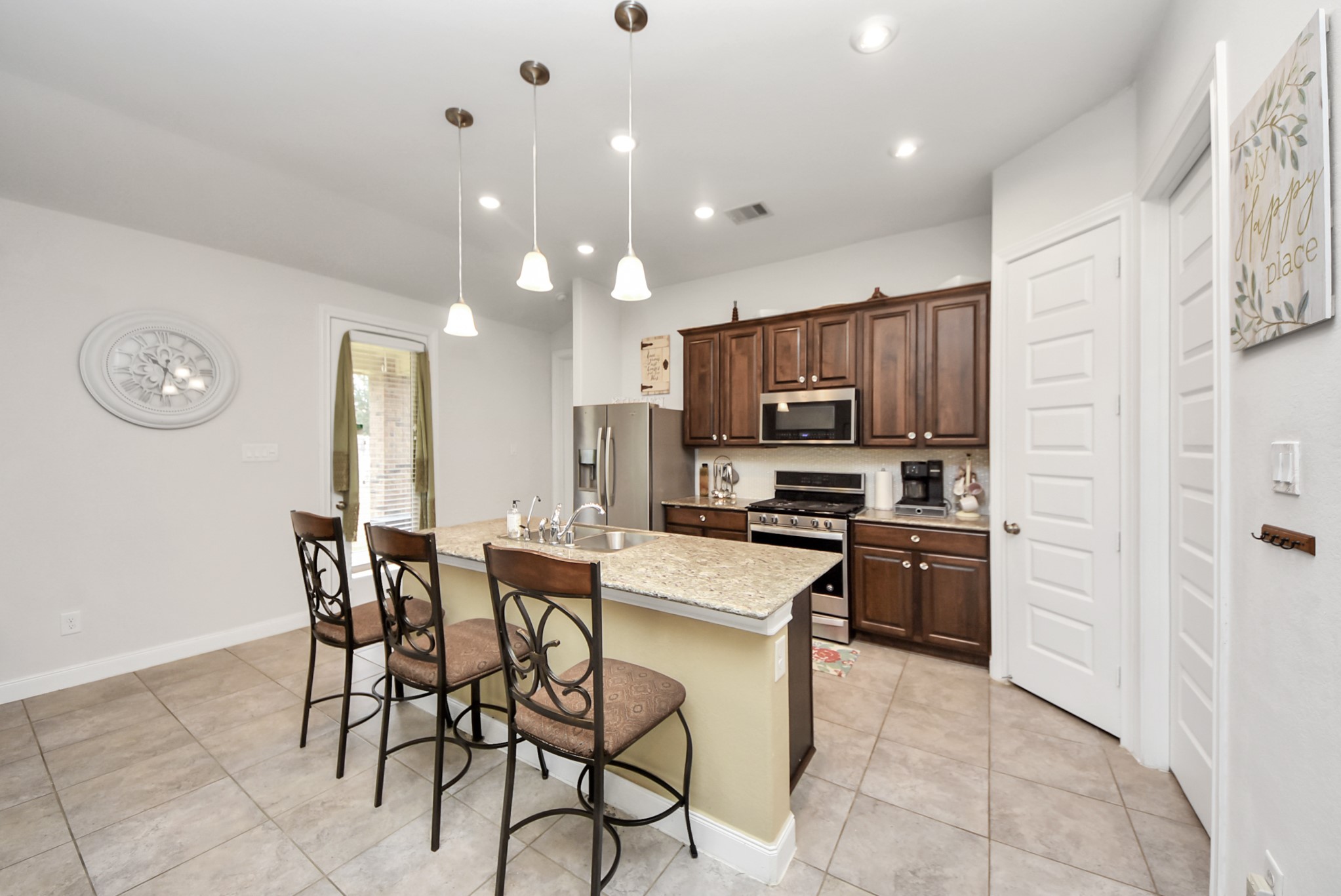 8806 Chapada Highlands Drive Cypress, TX 77433 - Photo 7 of 42 a kitchen with stainless steel appliances a refrigerator stove microwave and cabinets