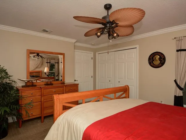 a bedroom with a bed and a flat tv screen on dresser