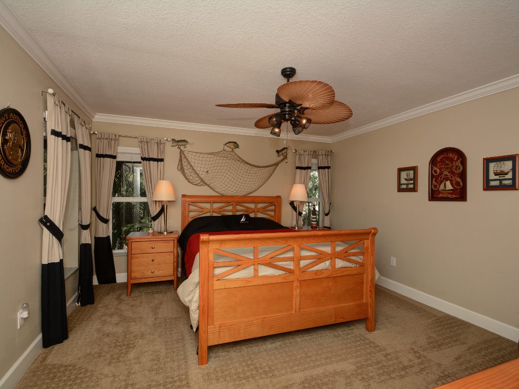 8705 Palm Tree Lane Vero Beach, FL 32963 - Photo 17 of 31 a bedroom with a bed and cabinets
