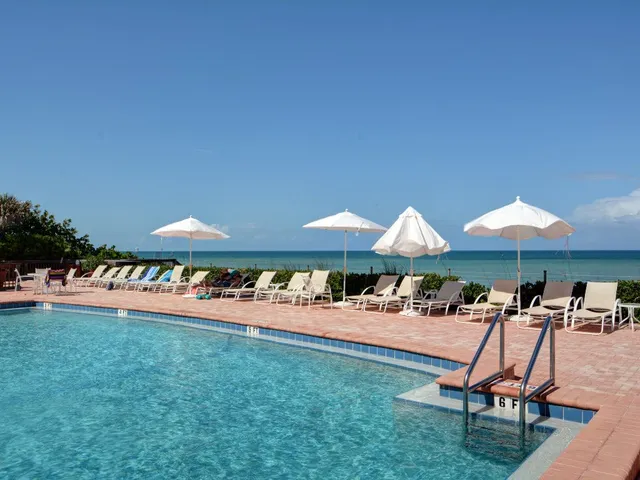a patio with a table and chairs under an umbrella