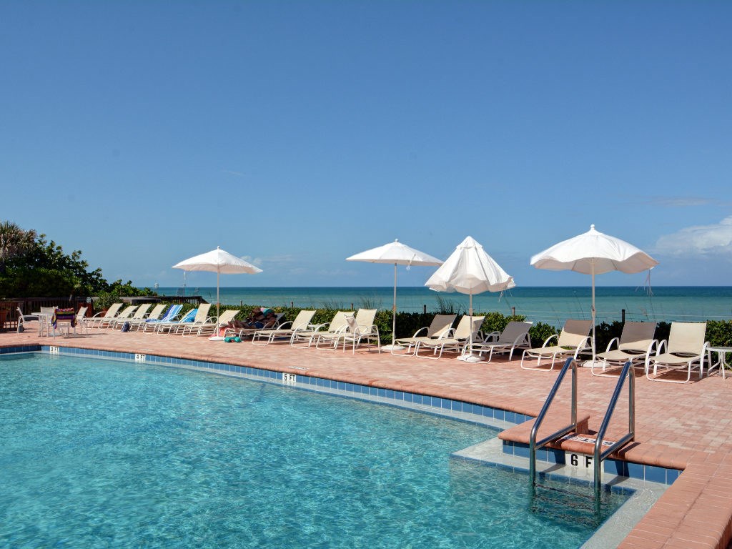8705 Palm Tree Lane Vero Beach, FL 32963 - Photo 20 of 31 a patio with a table and chairs under an umbrella