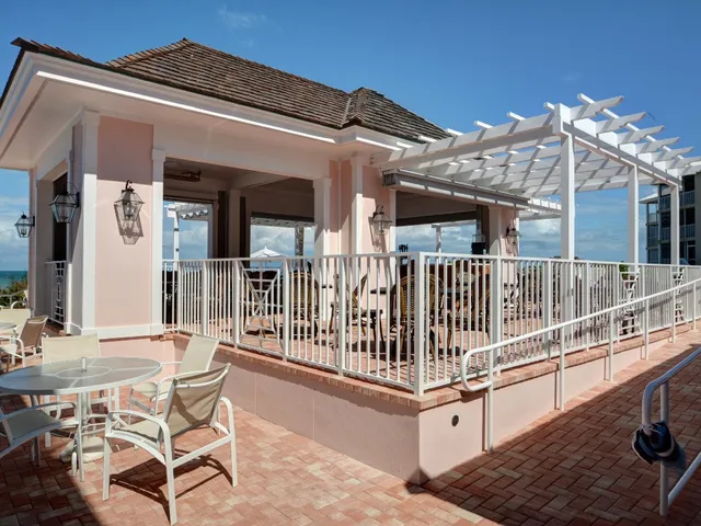 a view of a house with wooden deck and furniture