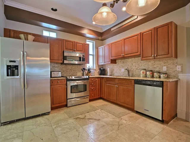 a kitchen with stainless steel appliances granite countertop a stove a sink and a refrigerator