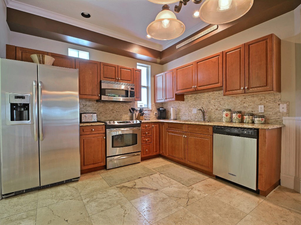 8705 Palm Tree Lane Vero Beach, FL 32963 - Photo 9 of 31 a kitchen with stainless steel appliances granite countertop a stove a sink and a refrigerator