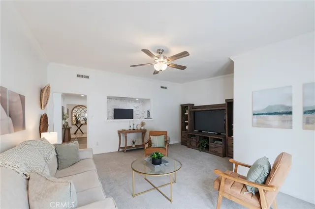 a living room with furniture a flat screen tv and a window